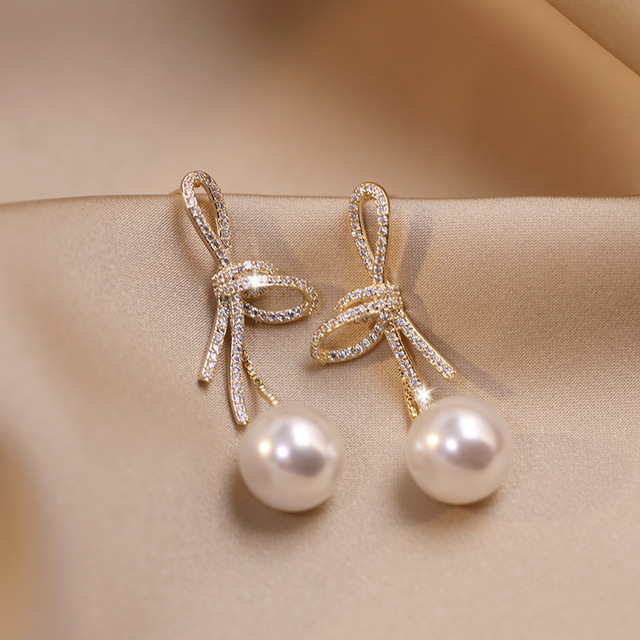 Pearl earrings with sparkling gold bow
