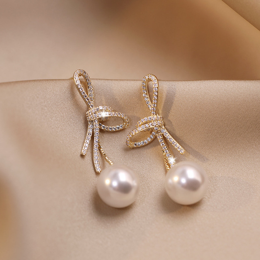 Pearl earrings with sparkling gold bow